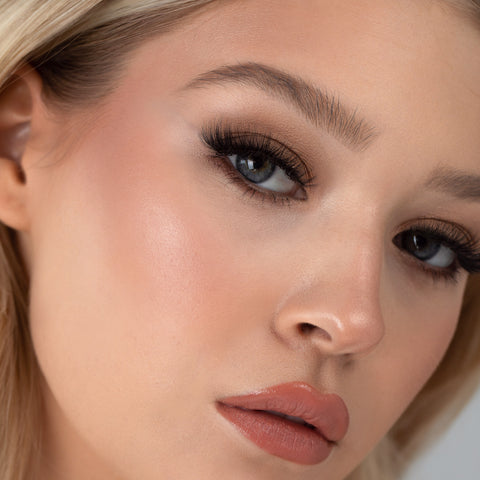 Lithe Lashes Bold Collection Style B1 - Tapered & Winged, an image of a model’s face wearing lithe lashes on both eyes, with full makeup, looking from a right side profile, semi zoomed in, displaying the elegance of the lashes on her eyes.