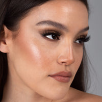 Lithe Lashes Bold Collection Style B4 - Wispy & Bold, an image of a model’s face wearing lithe lashes on both eyes, with full makeup, looking from a right side profile, semi zoomed in, displaying the elegance of the lashes on her eyes.