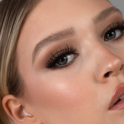 Lithe Lashes Bold Collection Style B3 - Kabuki, an image of a model’s face wearing lithe lashes on both eyes, with full makeup, looking from a right side profile, semi zoomed in, displaying the elegance of the lashes on her eyes.
