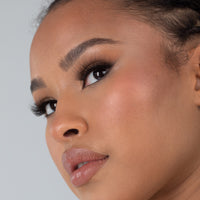 Lithe Lashes Bold Collection Style B5 - Fine & Fluttery, an image of a model’s face wearing lithe lashes on both eyes, with full makeup, looking from a left side profile, semi zoomed in, displaying the elegance of the lashes on her eyes.