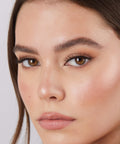 Lithe Lashes Core Collection lash style named 01 Fine and Delicate,  an image of a model’s face wearing lithe lashes on both eyes, with full makeup, looking from a left side profile, semi zoomed in, displaying the elegance of the lashes on her eyes.