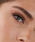 Lithe Lashes Core Collection lash style named 06 Natural and Classic, an image of a model’s face wearing lithe lashes on both eyes, with full makeup, looking from a right side profile, semi zoomed in, displaying the elegance of the lashes on her eyes.