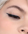 Lithe Lashes false lashes accessories Grip Liner, a 2-in-1 eyeliner lash adhesive. The model is wearing Lithe lashes and has used Grip Liner to apply the lashes to her eyes, also showing the eyeliner along the contour or her eyes as well.